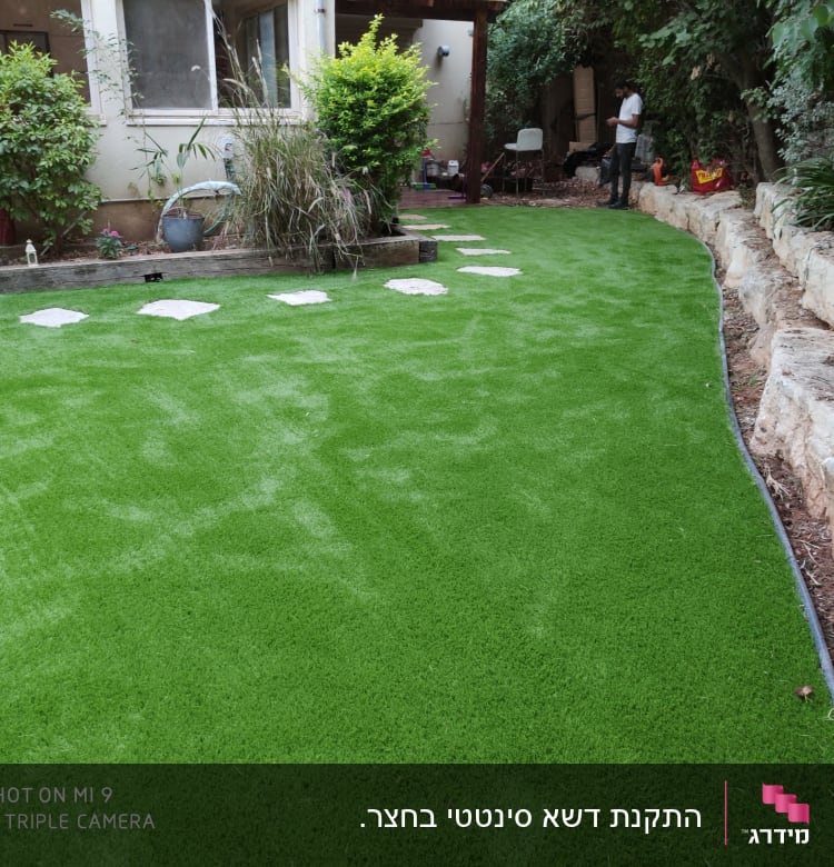 דשא סינתטי עם אבנים בשביל בגינה